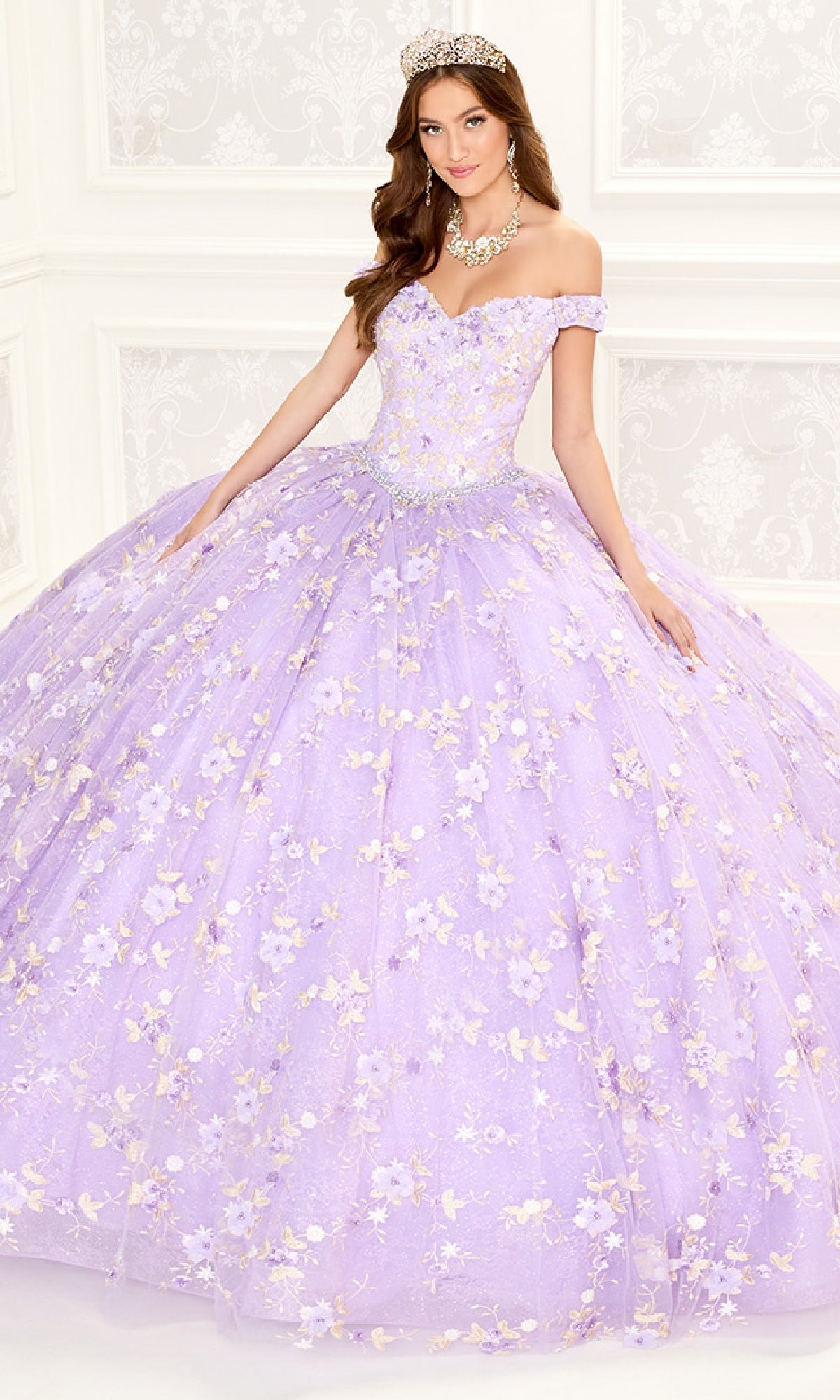 A woman wearing a tiara and necklace poses in a light purple off-shoulder Quinceanera Dress PR30084 By Princesa with a corset back and floral embroidery, set in a white ornate room.